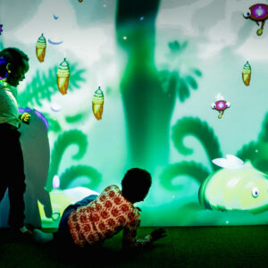Barn som leker med den interaktive sanseveggen i lekeuniverset