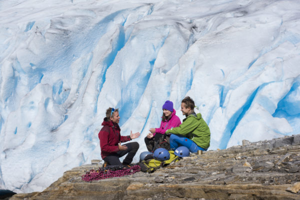 En instruktør forklarer hvordan man skal gå på isbre, med isbre i bakgrunnen