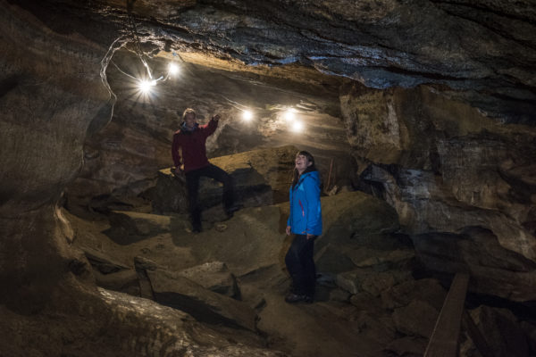 To personer som er inne i en grotte med belysning